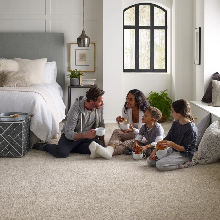 Family enjoying snacks sitting on carpet | Bowlings Carpet